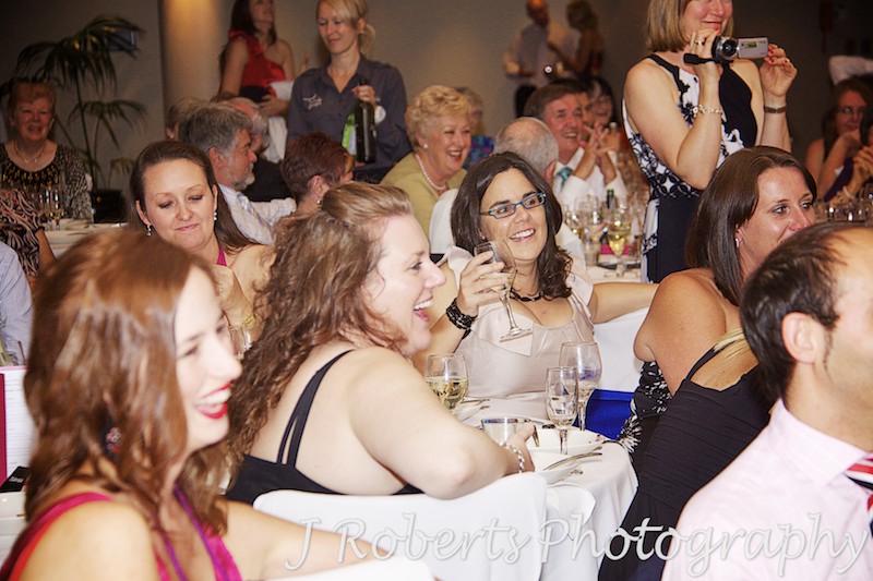 Guests laughing during speeches at wedding reception - wedding photography sydney
